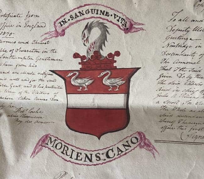 A red and white coat of arms with two swans above a horizontal white stripe, a serpent crest, and Latin mottos: "IN SANGUINE VITA" above and "MORIENS CANO" below. Handwritten text surrounds the shield, reflecting the rich tradition celebrated during National Heritage Week.